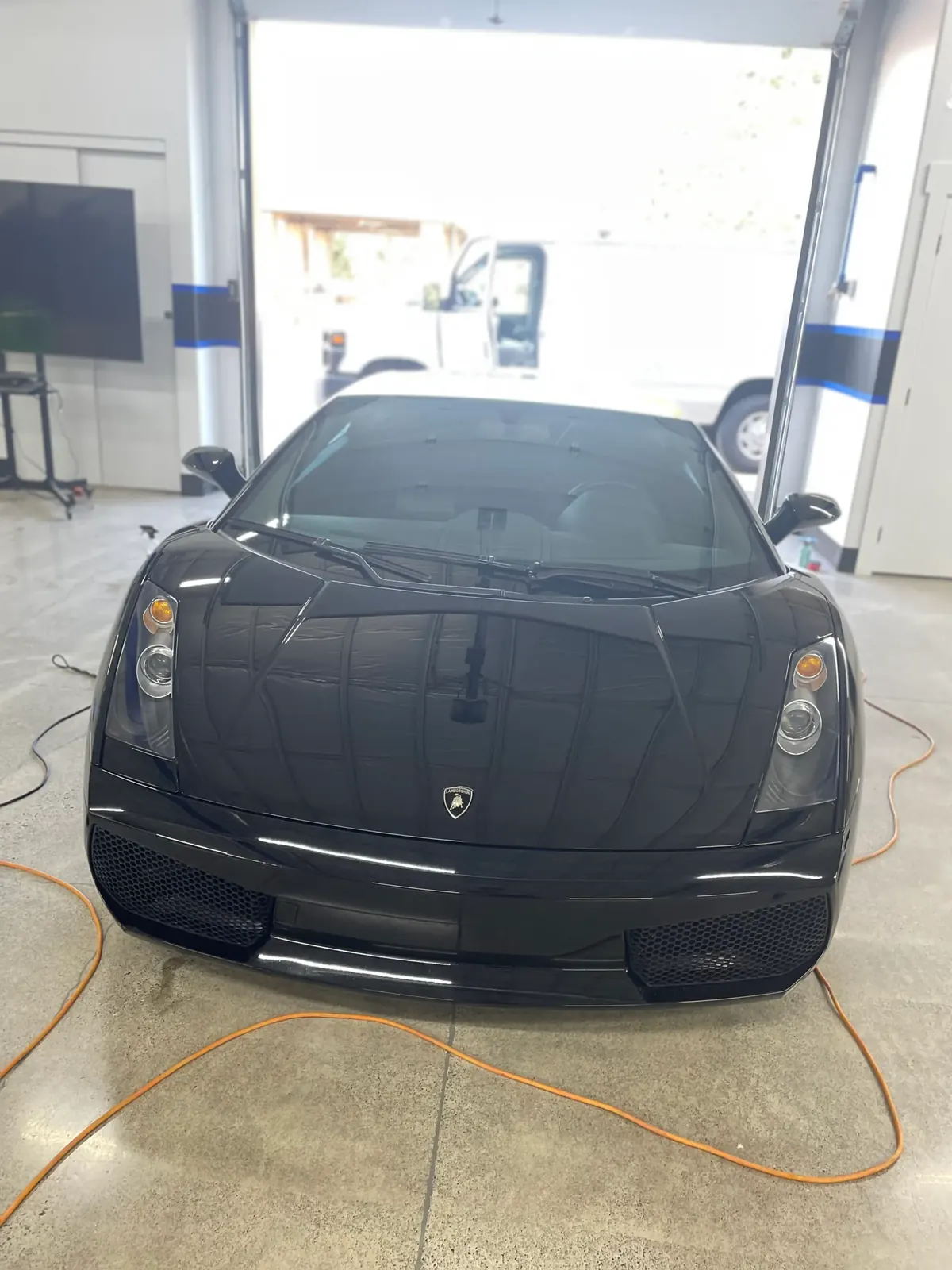 Black Lamborghini Gallardo head-on in the detailing bay after its coating