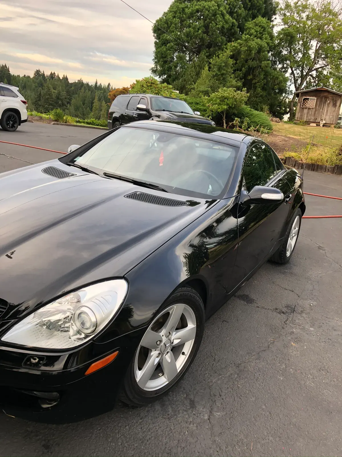 Black Mercedes-Benz SLK roadster at dusk with a polished finish